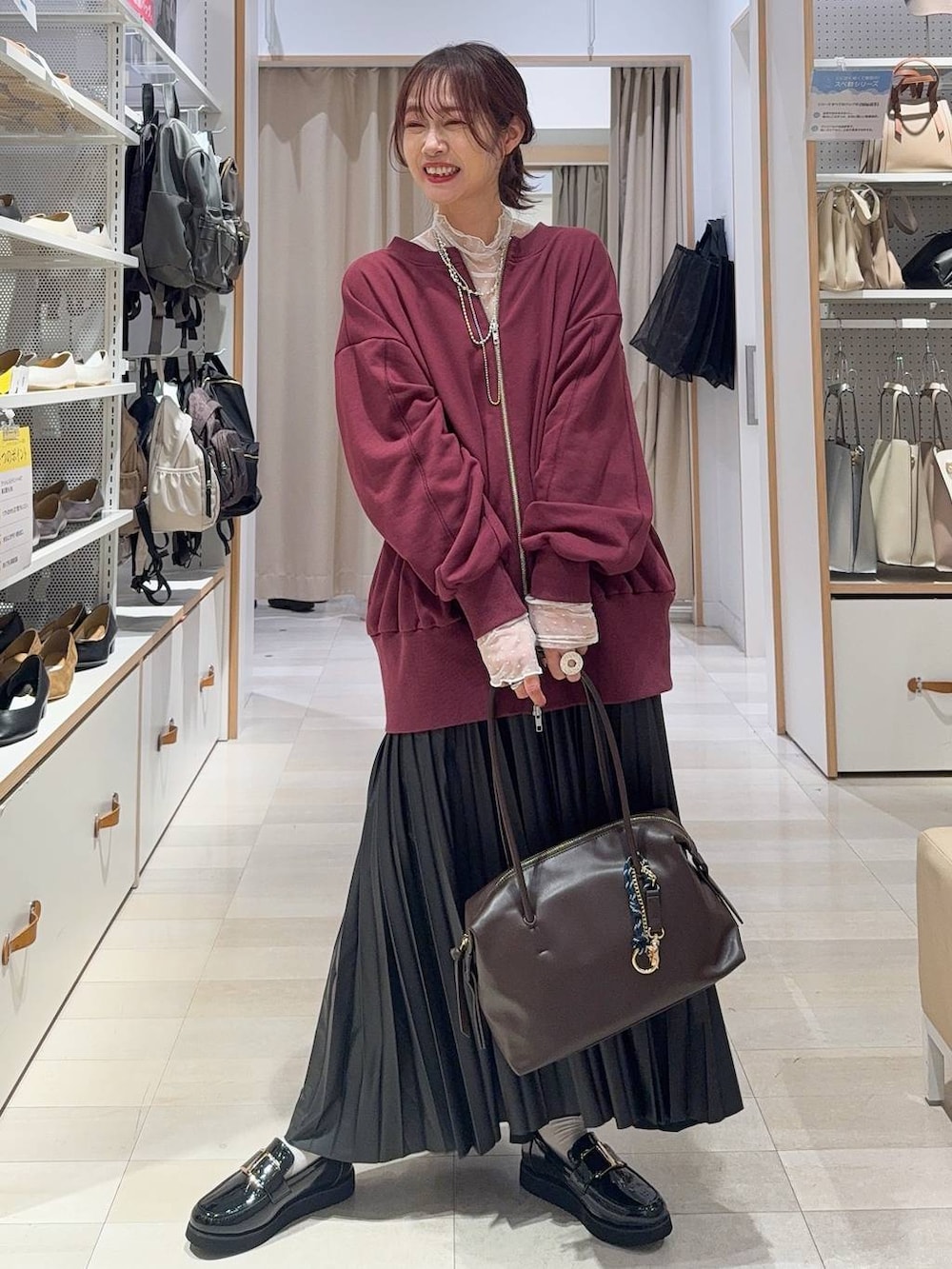 ホワイト系のキャミソール、ブルー系のデニムパンツ、ブラック系のボストンバッグを着用したレディースの秋コーディネートの5枚目の写真