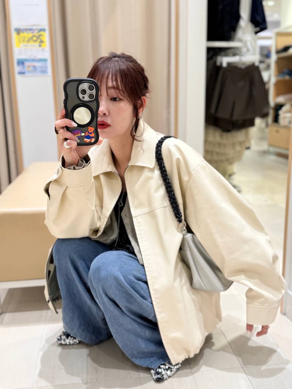 ホワイト系のブルゾン、ブルー系のデニムパンツを着用したレディースの春コーディネートの2枚目の写真