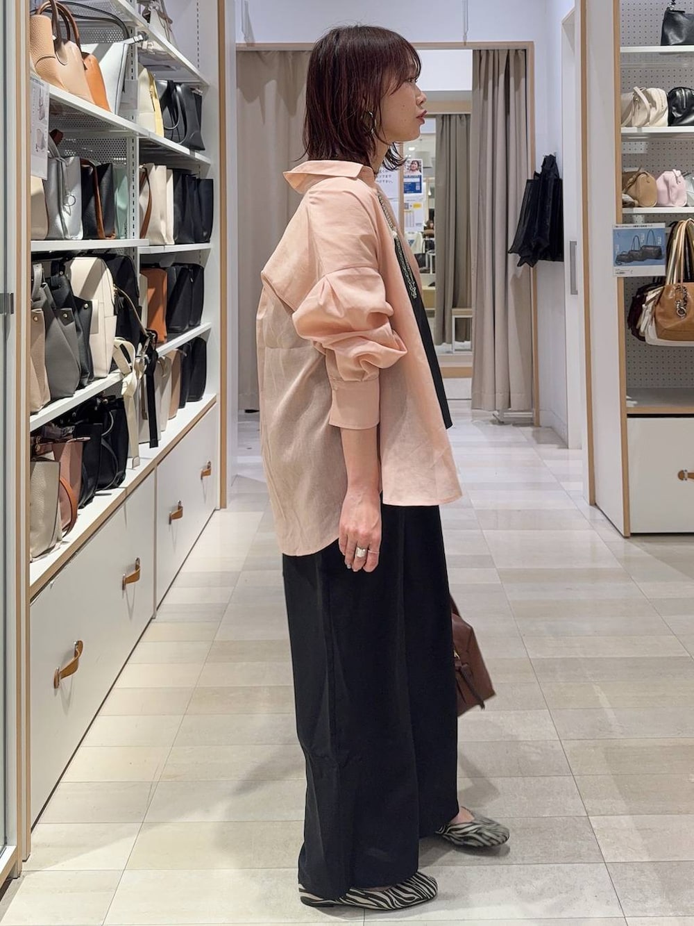 その他のパンプス、ブラウン系のボストンバッグ、シルバー系のネックレスを着用したレディースの春コーディネートの2枚目の写真