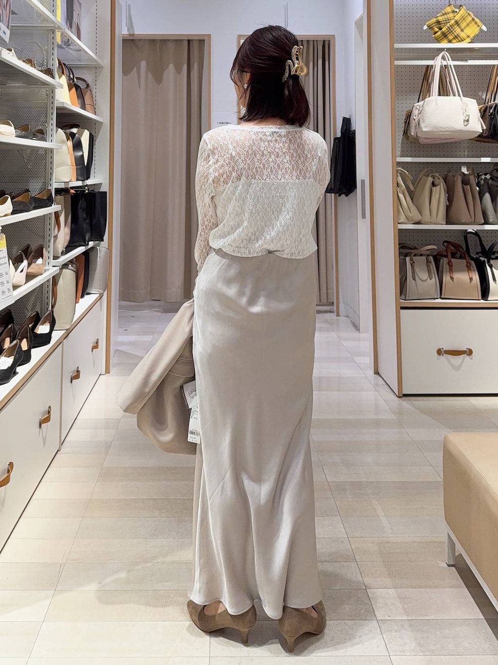 ベージュ系のショルダーバッグ、ベージュ系のパンプス、ホワイト系のキャミソールを着用したレディースの冬コーディネートの8枚目の写真