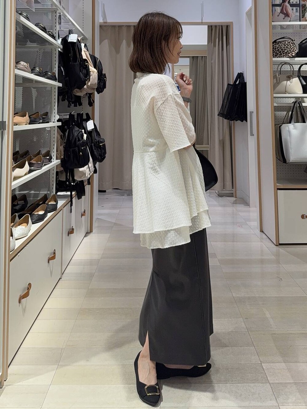 ホワイト系のショルダーバッグ、ブラック系のパンプス、ホワイト系のキャミソールを着用したレディースの夏コーディネートの5枚目の写真