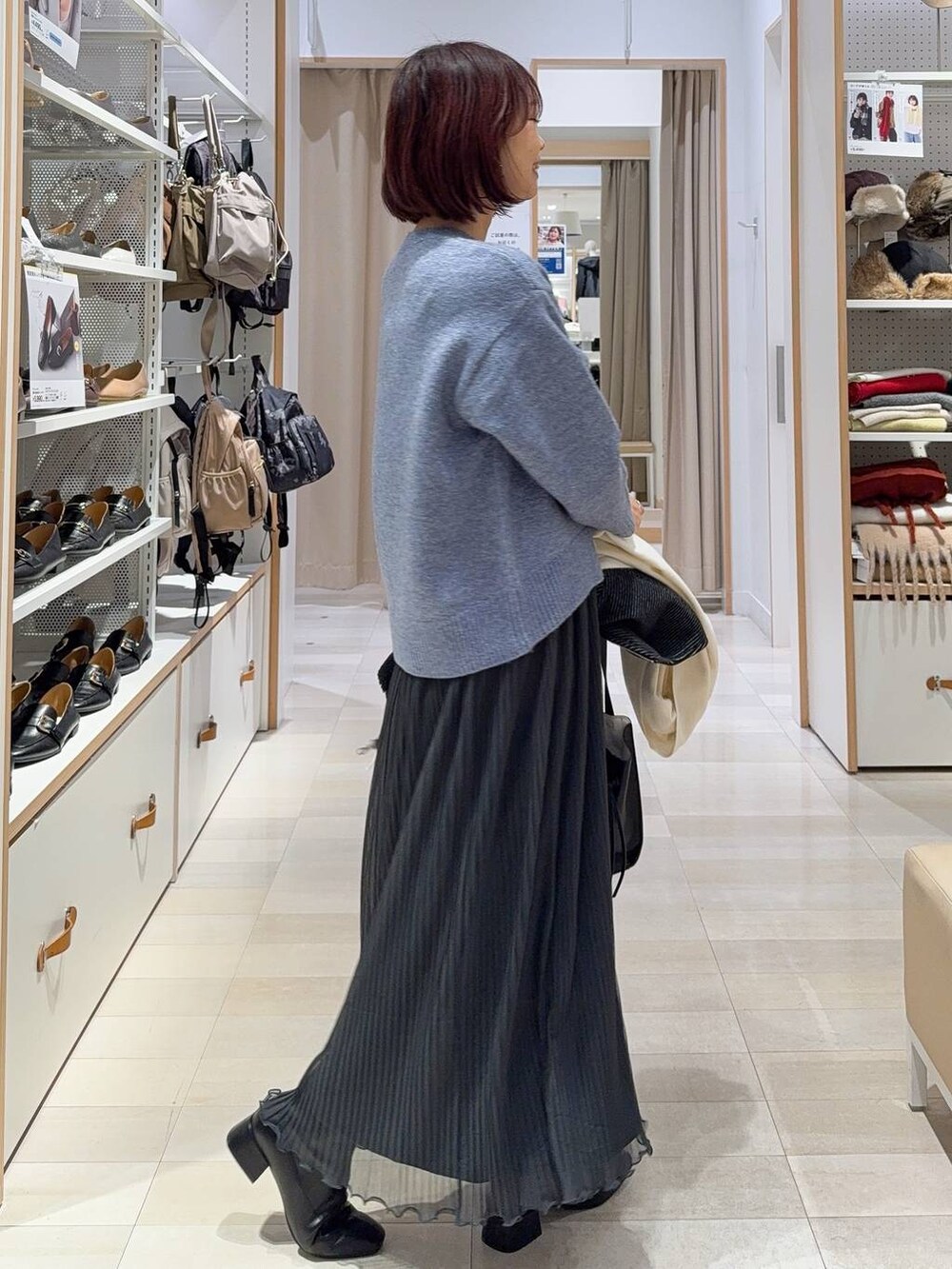 ホワイト系のショルダーバッグ、グレー系のノーカラージャケット、ブラック系のブーツを着用したレディースの秋コーディネートの6枚目の写真