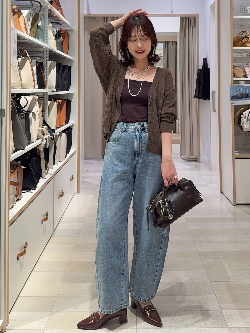 ブルー系のデニムパンツ、ブラウン系のキャミソール、ブラウン系のローファーを着用したレディースの春コーディネートの2枚目の写真