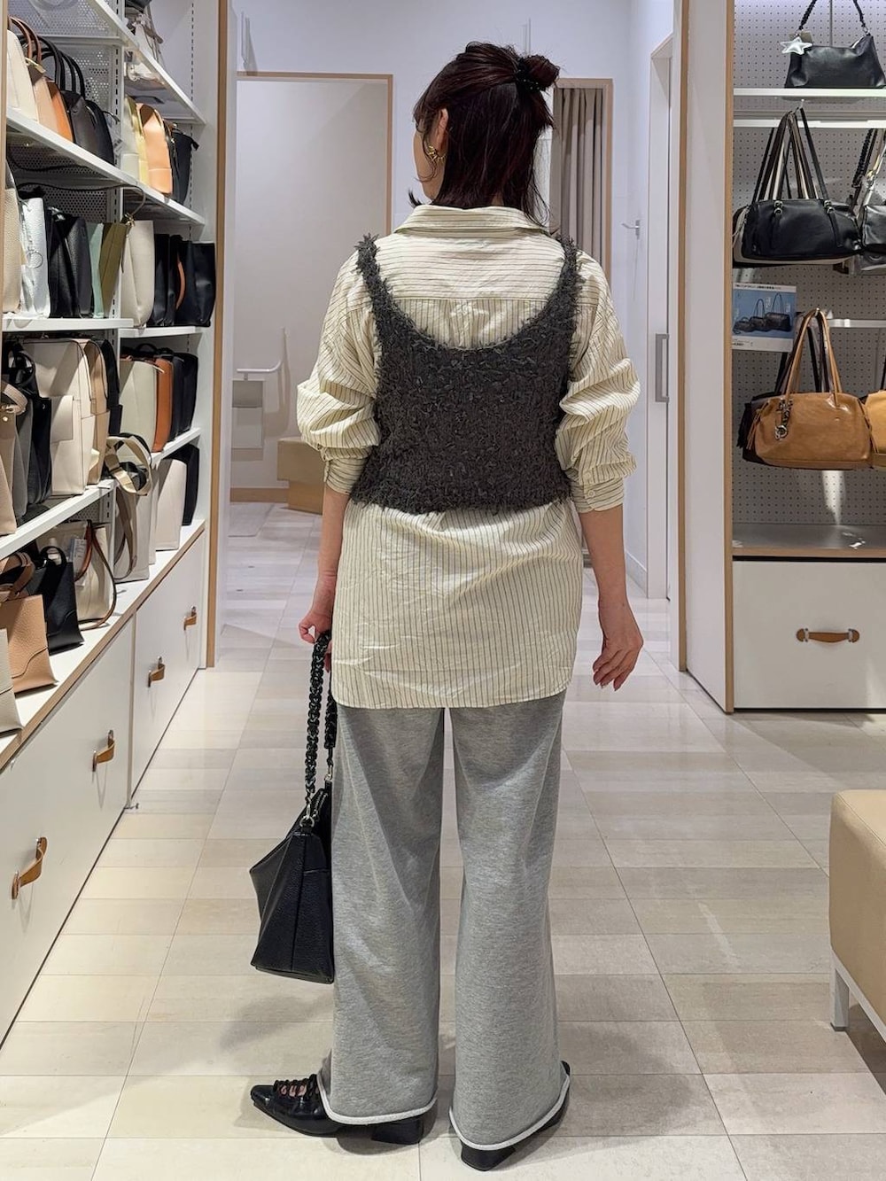 イエロー系のシャツ/ブラウス、グレー系のスウェットパンツ、グレー系のベストを着用したレディースの春コーディネートの8枚目の写真