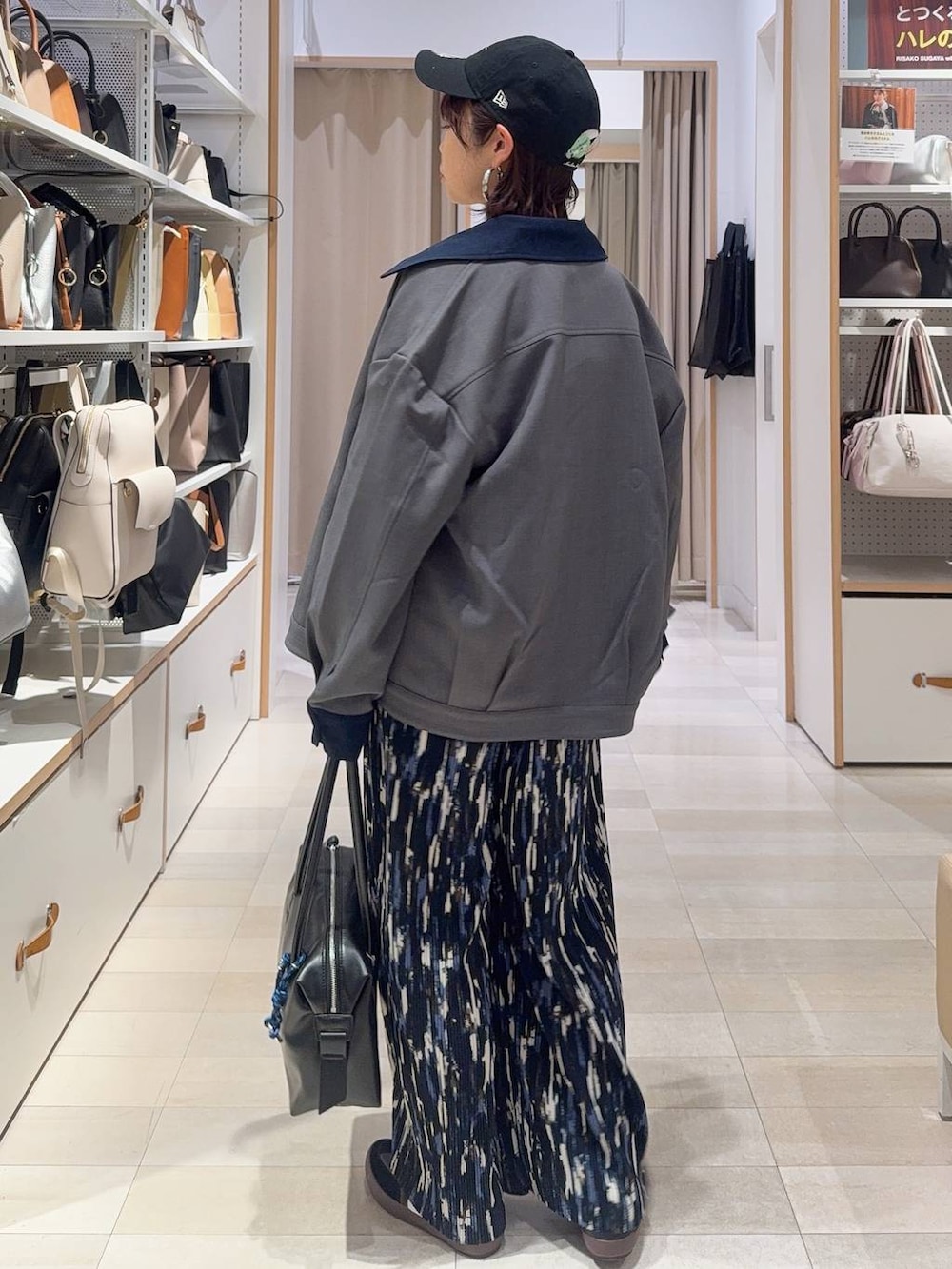 ブラック系のスニーカー、ブラック系のボストンバッグ、ブルー系のニット/セーターを着用したレディースの冬コーディネートの5枚目の写真