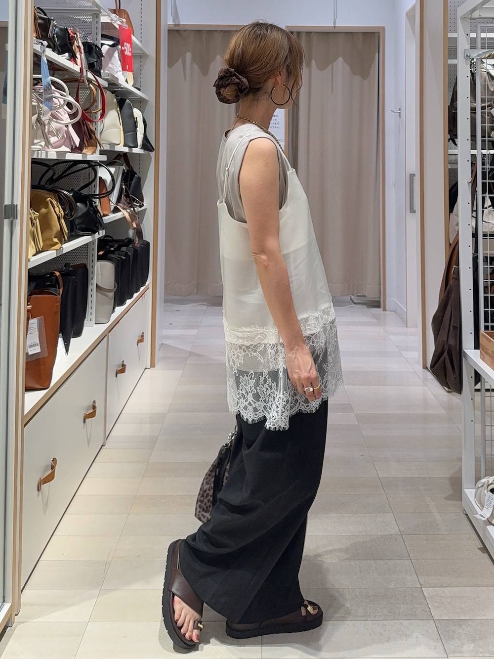 ブラック系のその他パンツ、ホワイト系のキャミソール、ブラウン系のサンダルを着用したレディースの夏コーディネートの5枚目の写真