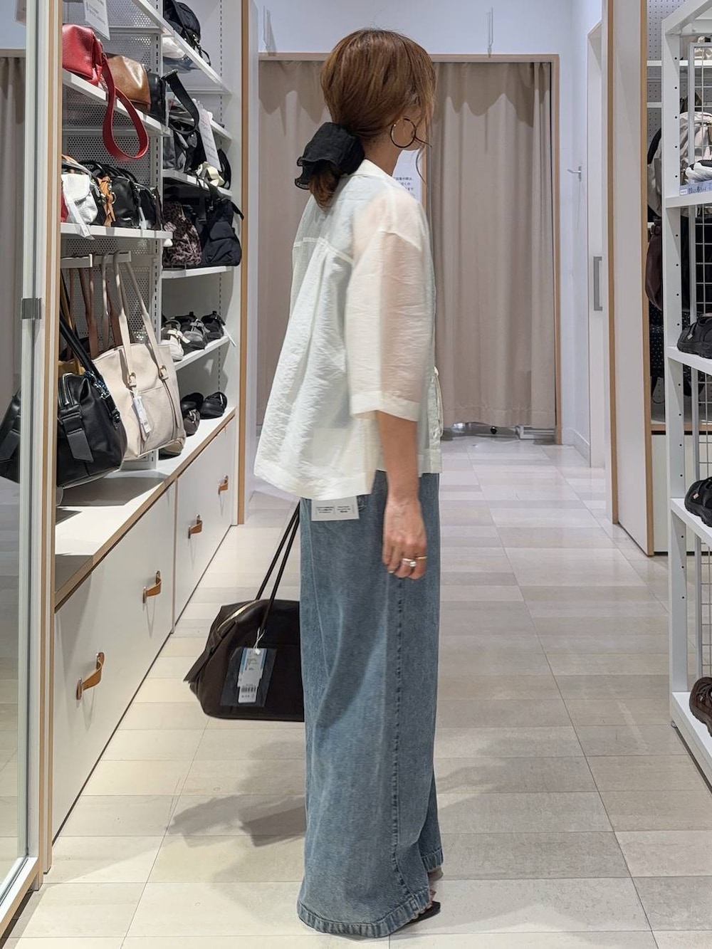 ブラウン系のボストンバッグ、ブラウン系のその他パンツ、ホワイト系のシャツ/ブラウスを着用したレディースの夏コーディネートの4枚目の写真