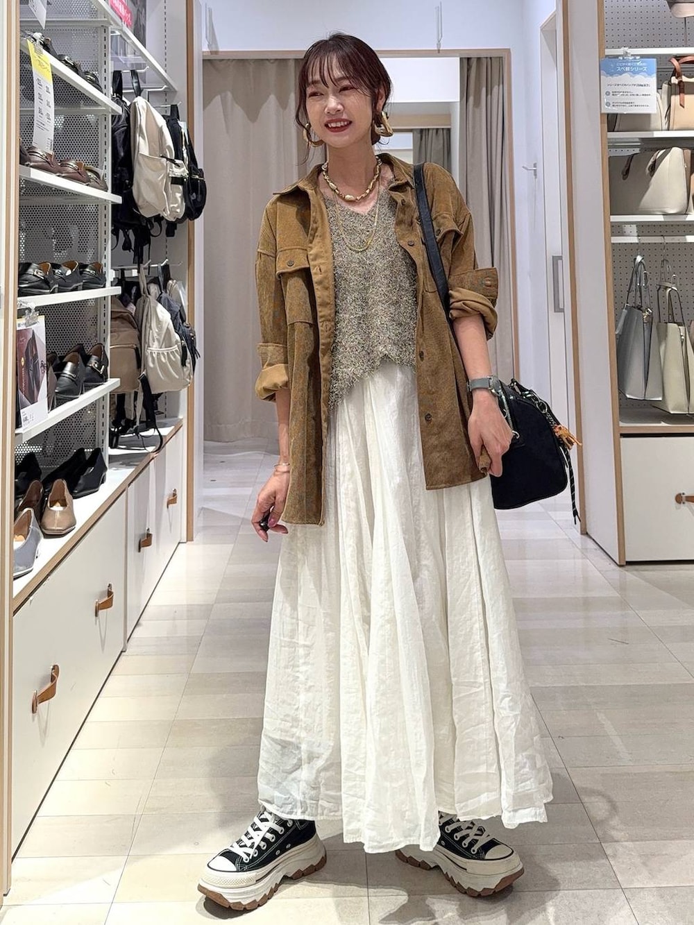 イエロー系のシャツ/ブラウス、ベージュ系のスカート、ブラック系のボストンバッグを着用したレディースの秋コーディネートの3枚目の写真