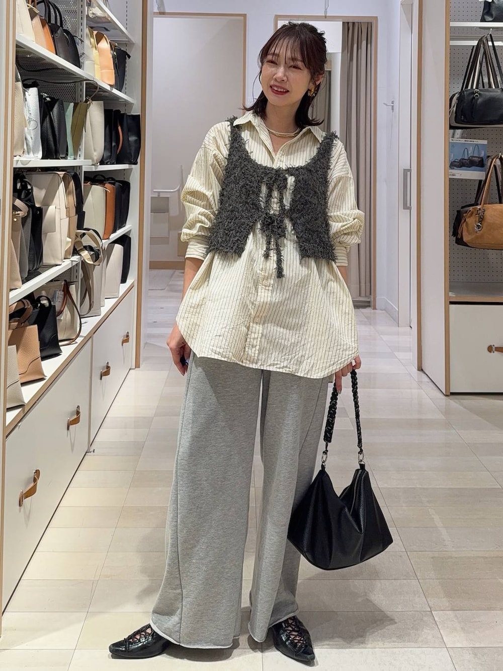 イエロー系のシャツ/ブラウス、グレー系のスウェットパンツ、グレー系のベストを着用したレディースの春コーディネートの3枚目の写真