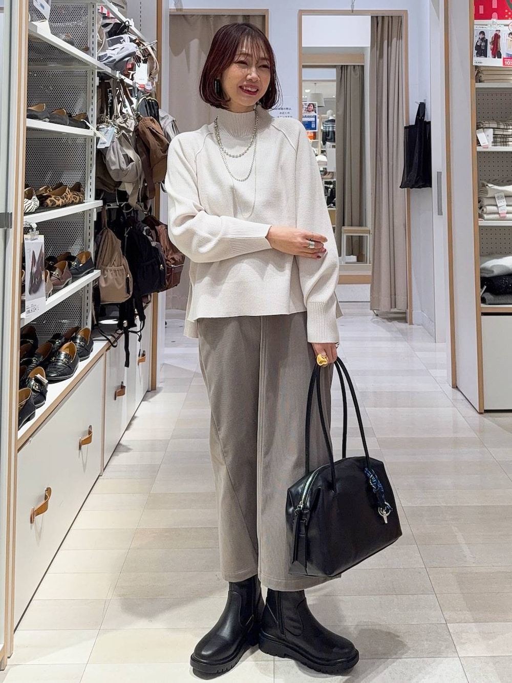 ブラウン系のバックパック/リュック、ブラウン系のスカート、ブラック系のブーツを着用したレディースの冬コーディネートの3枚目の写真