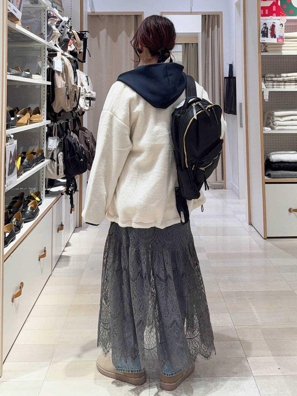 ホワイト系のブルゾン、ブルー系のデニムパンツ、ブラック系のバックパック/リュックを着用したレディースの冬コーディネートの7枚目の写真