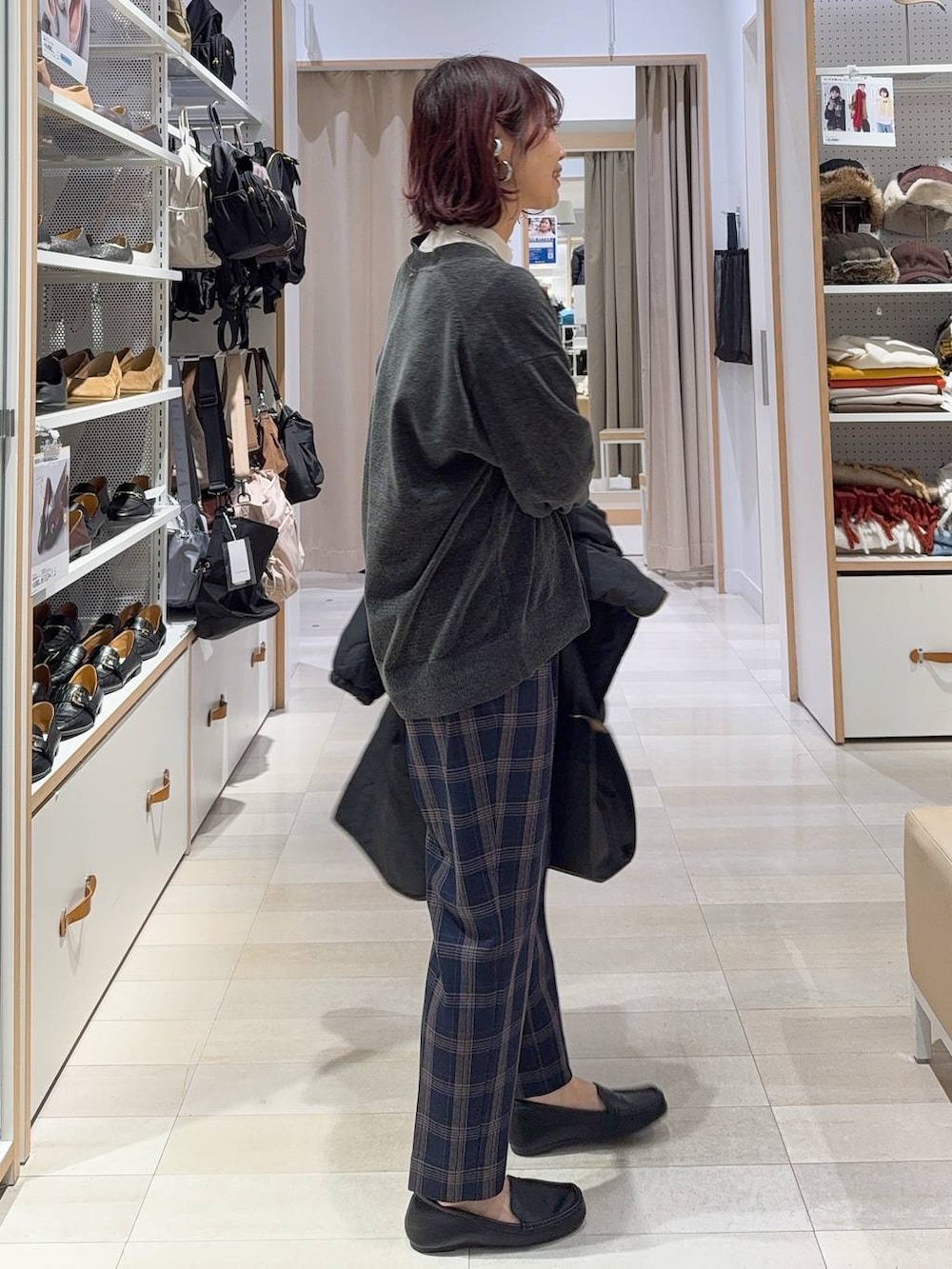 ブラック系のショルダーバッグ、ブラック系のブルゾン、ホワイト系のニット/セーターを着用したレディースの冬コーディネートの5枚目の写真