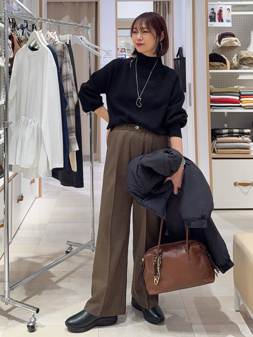 ブラウン系のボストンバッグ、ブラウン系のその他パンツ、ブラウン系のその他シューズを着用したレディースの冬コーディネートの3枚目の写真