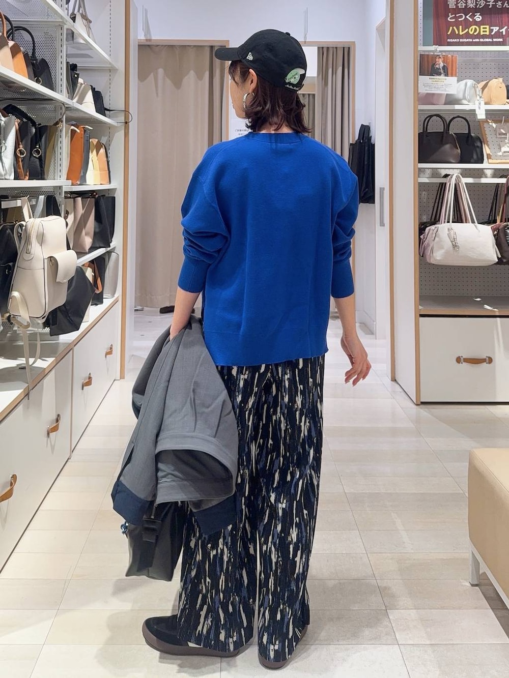 ブラック系のスニーカー、ブラック系のボストンバッグ、ブルー系のニット/セーターを着用したレディースの冬コーディネートの7枚目の写真