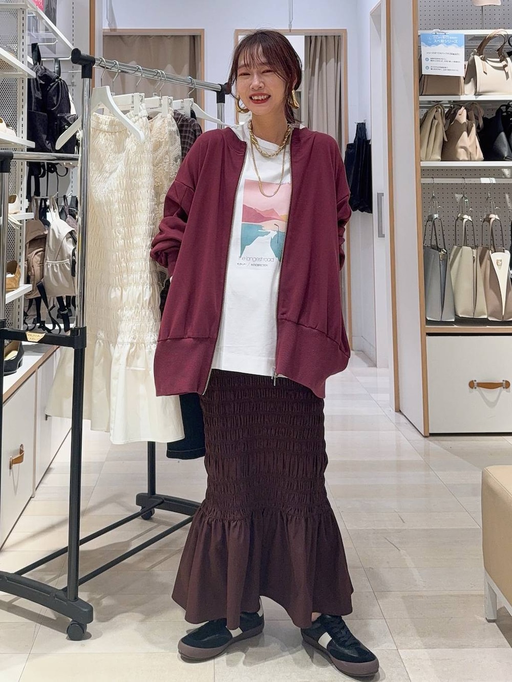 ホワイト系のキャミソール、ブルー系のデニムパンツ、ブラック系のボストンバッグを着用したレディースの秋コーディネートの8枚目の写真