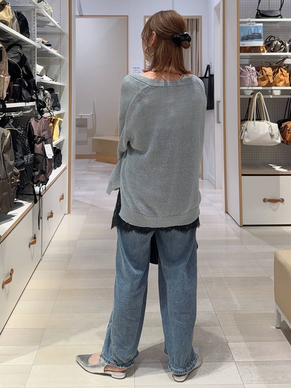 ブルー系のデニムパンツ、ブラック系のキャミソール、ブルー系のカーディガン/ボレロを着用したレディースの春コーディネートの6枚目の写真