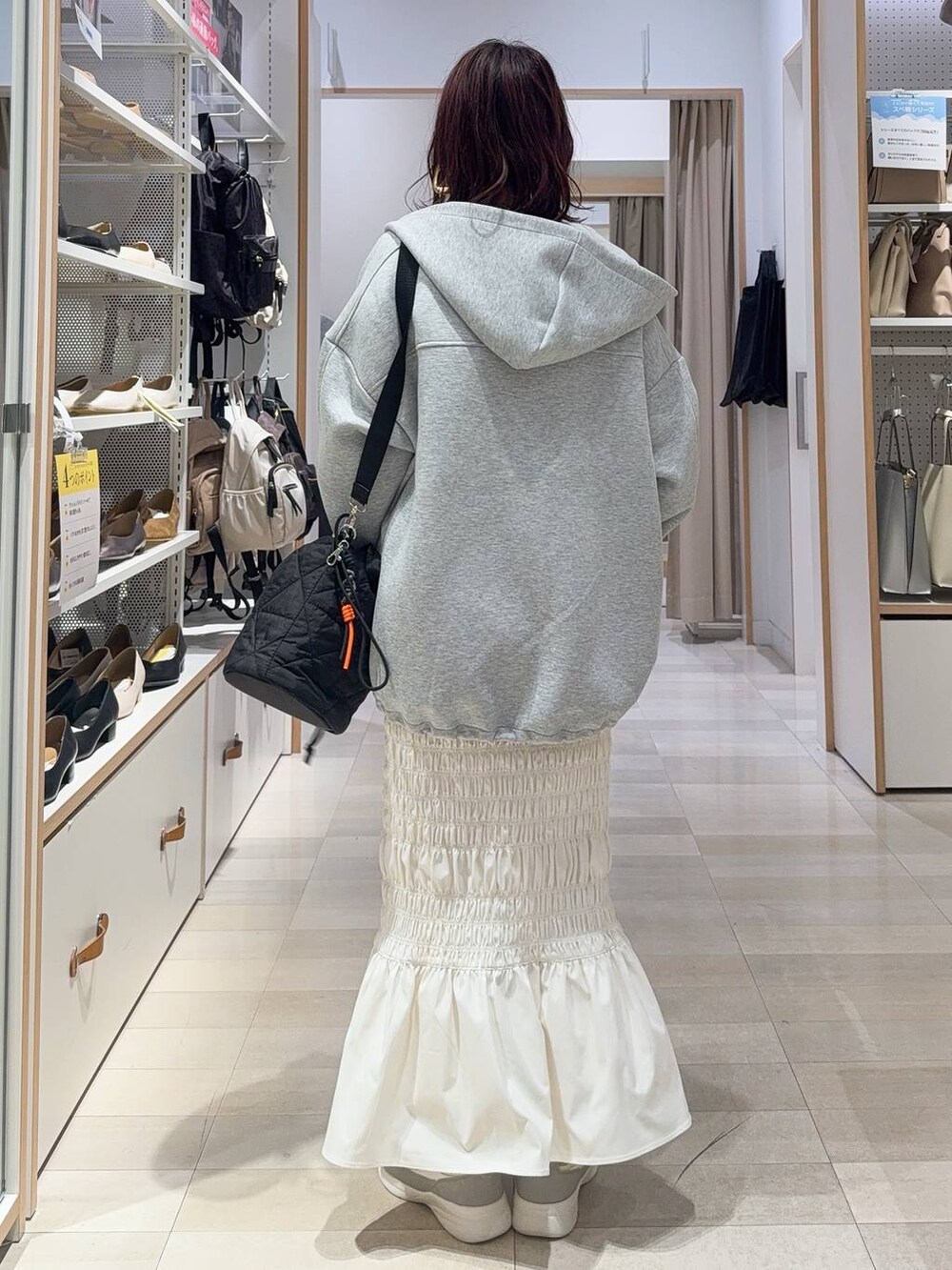 ホワイト系のスニーカー、ブラック系のキャミソール、ブラック系のハンドバッグを着用したレディースの秋コーディネートの5枚目の写真