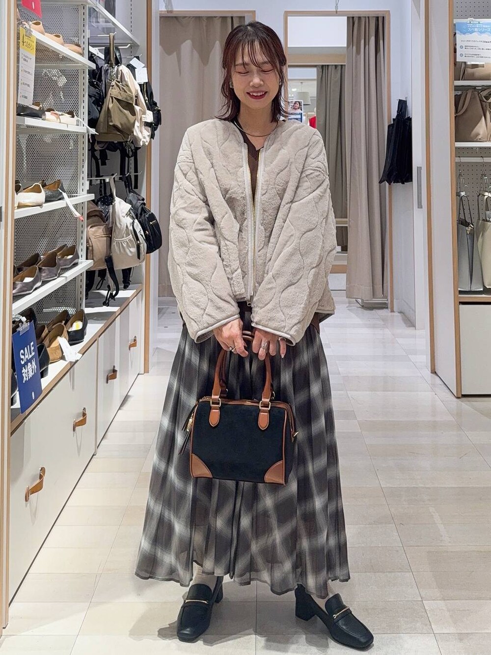 ブラック系のローファー、ベージュ系のブルゾン、ブラウン系のスウェットを着用したレディースの秋コーディネートの2枚目の写真