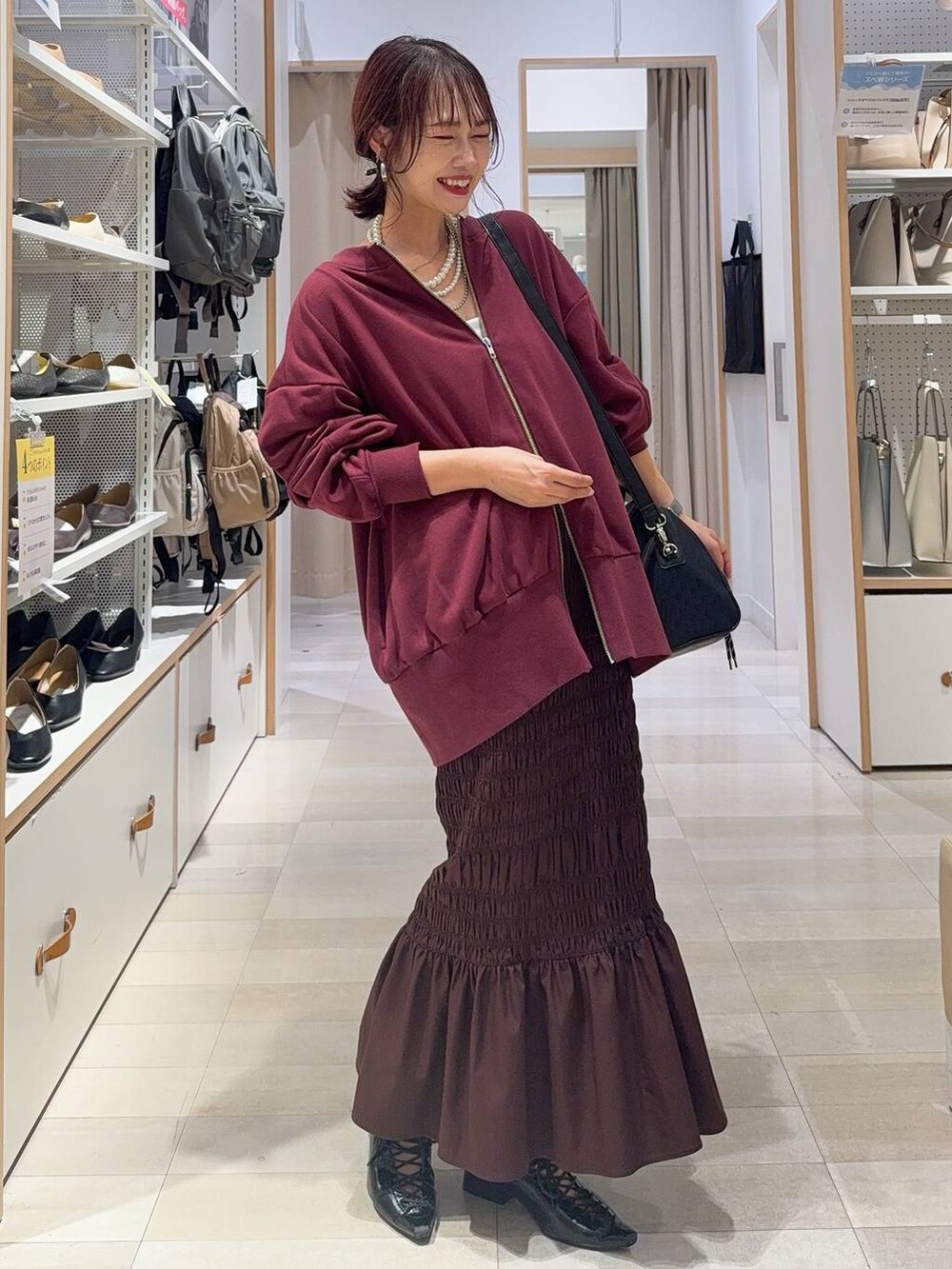 ホワイト系のキャミソール、ブルー系のデニムパンツ、ブラック系のボストンバッグを着用したレディースの秋コーディネートの4枚目の写真