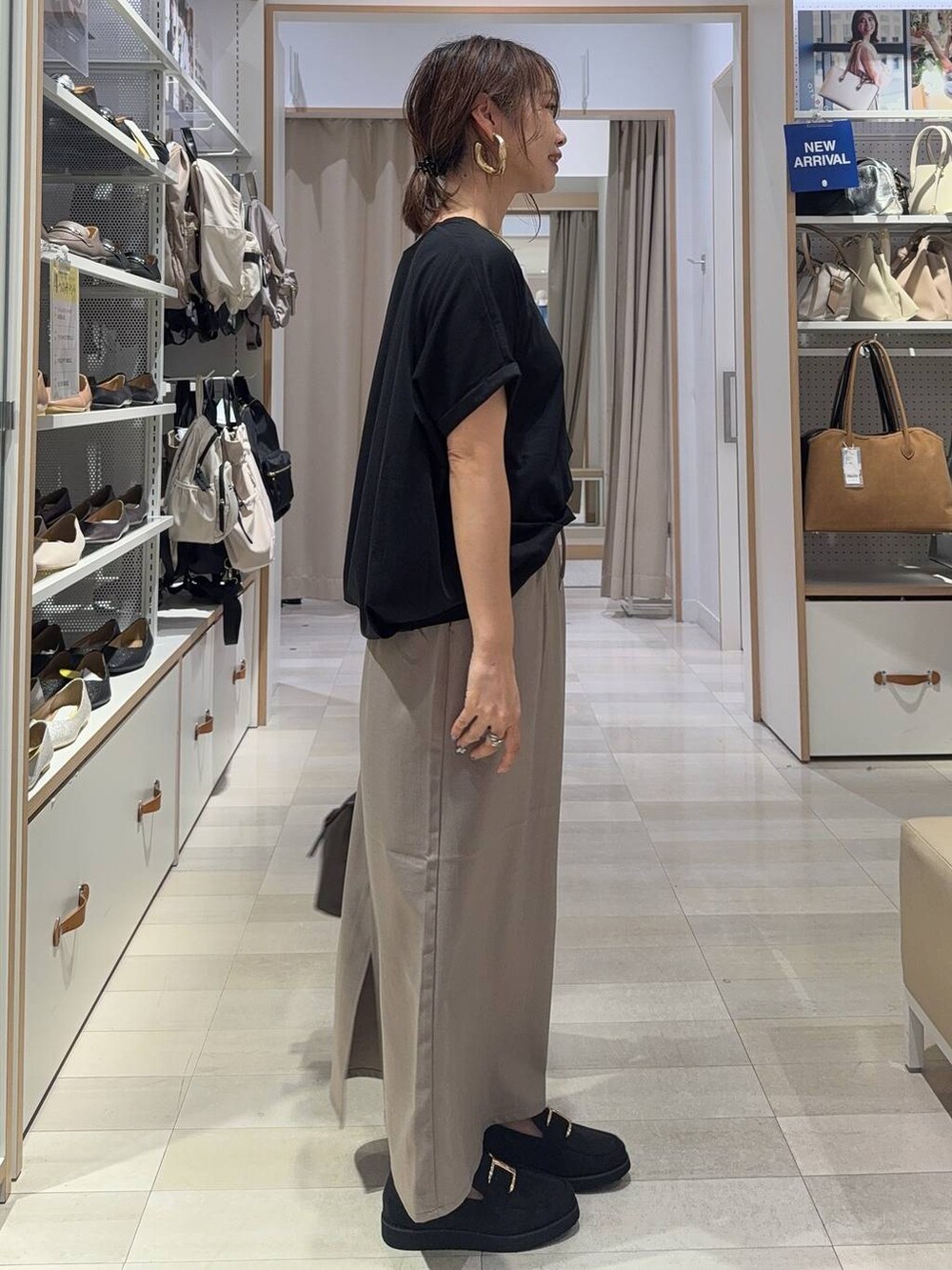 ブラック系のローファー、ブラック系のショルダーバッグ、ブラック系のTシャツ/カットソーを着用したレディースの夏コーディネートの7枚目の写真