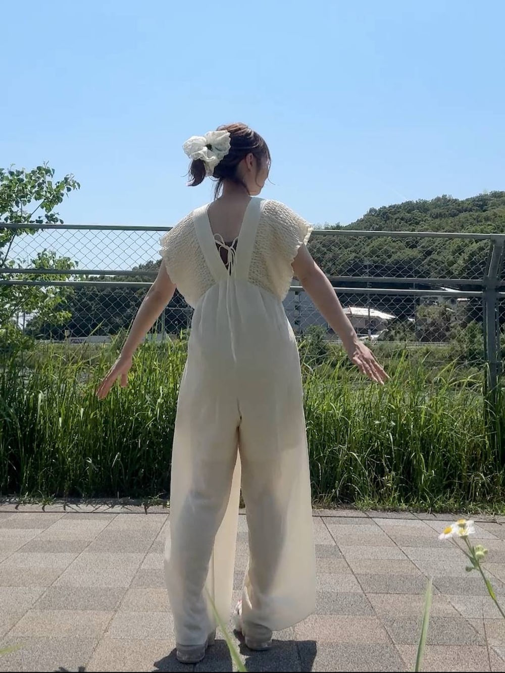 ホワイト系のサロペット/オーバーオール、ブラウン系のキャミソール、ホワイト系のシュシュを着用したレディースの夏コーディネートの4枚目の写真