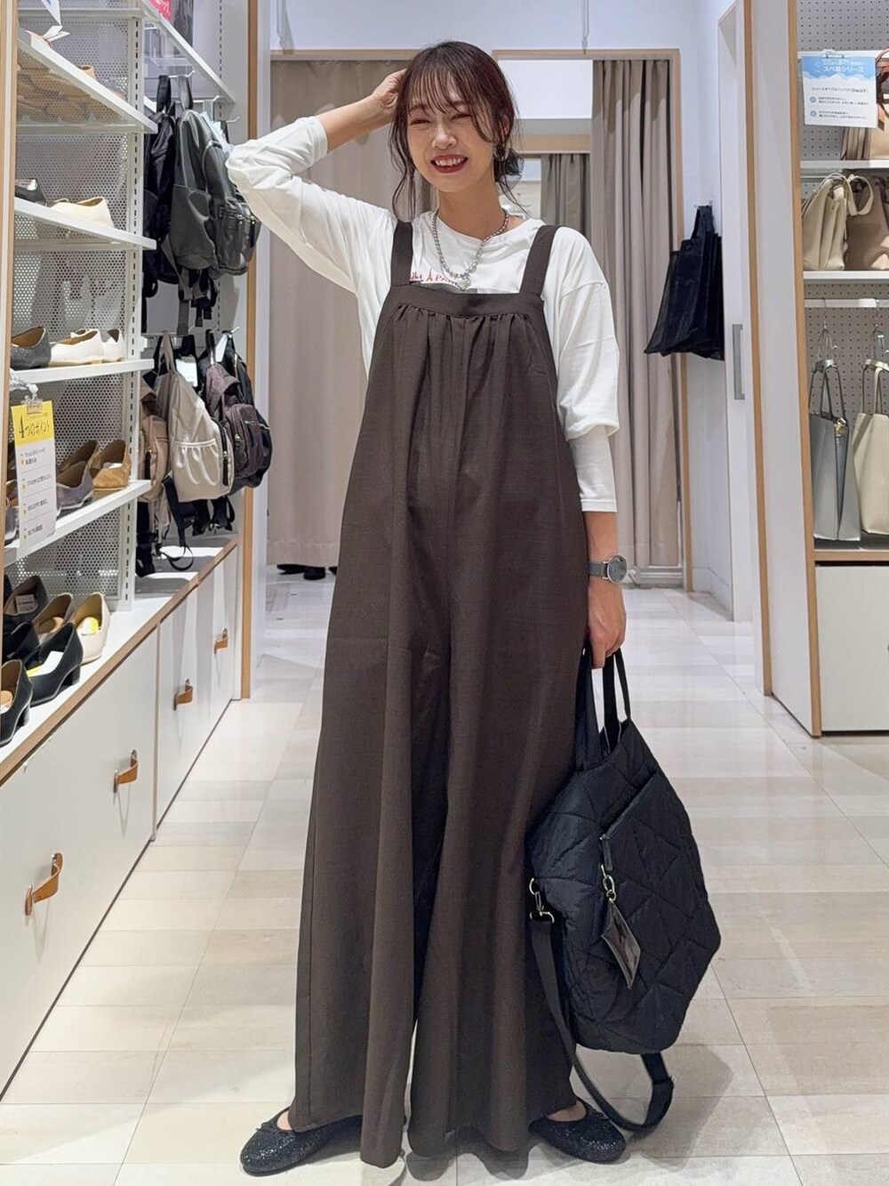 ブラック系のバレエシューズ、ブラック系のショルダーバッグ、ホワイト系のTシャツ/カットソーを着用したレディースの秋コーディネートの2枚目の写真