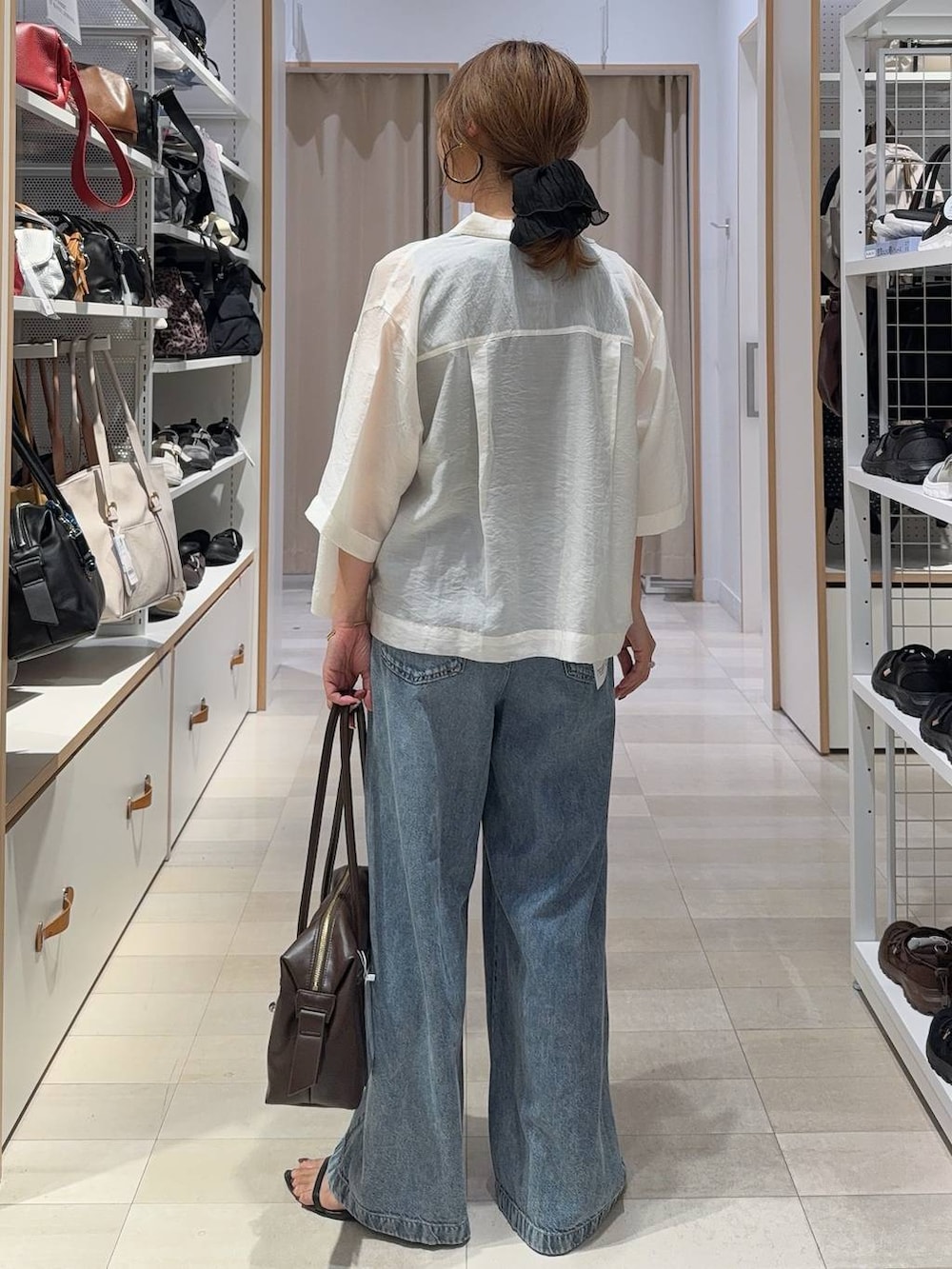 ブラウン系のボストンバッグ、ブラウン系のその他パンツ、ホワイト系のシャツ/ブラウスを着用したレディースの夏コーディネートの5枚目の写真