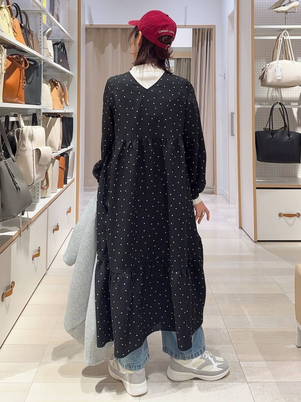 ホワイト系のスニーカー、ブルー系のデニムパンツ、ホワイト系のニット/セーターを着用したレディースの冬コーディネートの7枚目の写真