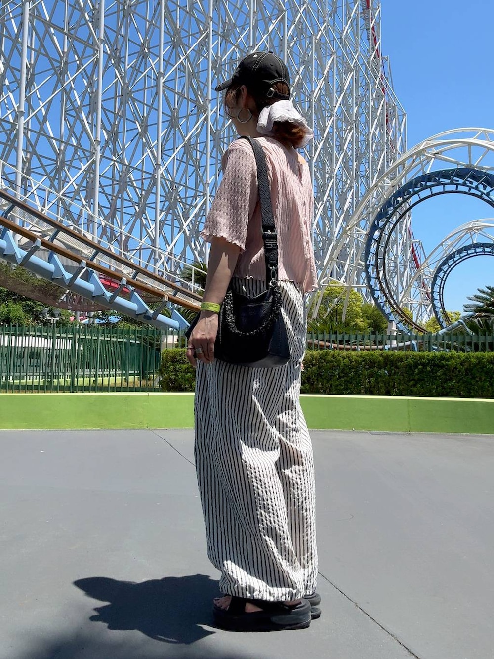 ホワイト系のその他パンツ、シルバー系のネックレス、ブラック系のキャップを着用したレディースの春コーディネートの4枚目の写真