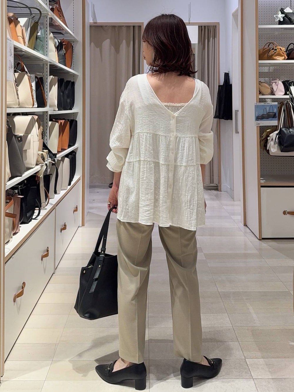 ベージュ系のその他パンツ、ベージュ系のベスト、ブラック系のハンドバッグを着用したレディースの春コーディネートの5枚目の写真