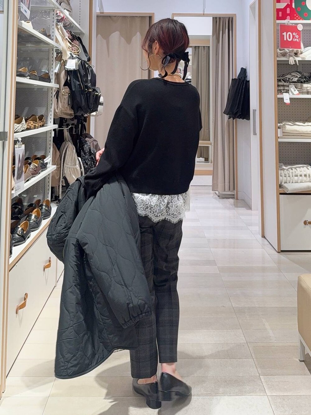 ホワイト系のショルダーバッグ、ブラック系のブルゾン、ブラック系のその他パンツを着用したレディースの冬コーディネートの7枚目の写真