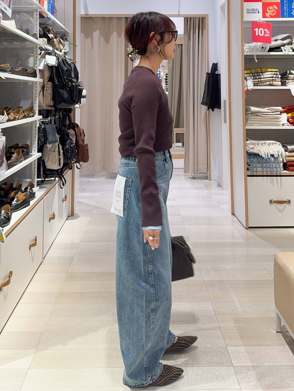 その他のパンプス、ブラウン系のボストンバッグ、ブルー系のデニムパンツを着用したレディースの冬コーディネートの8枚目の写真