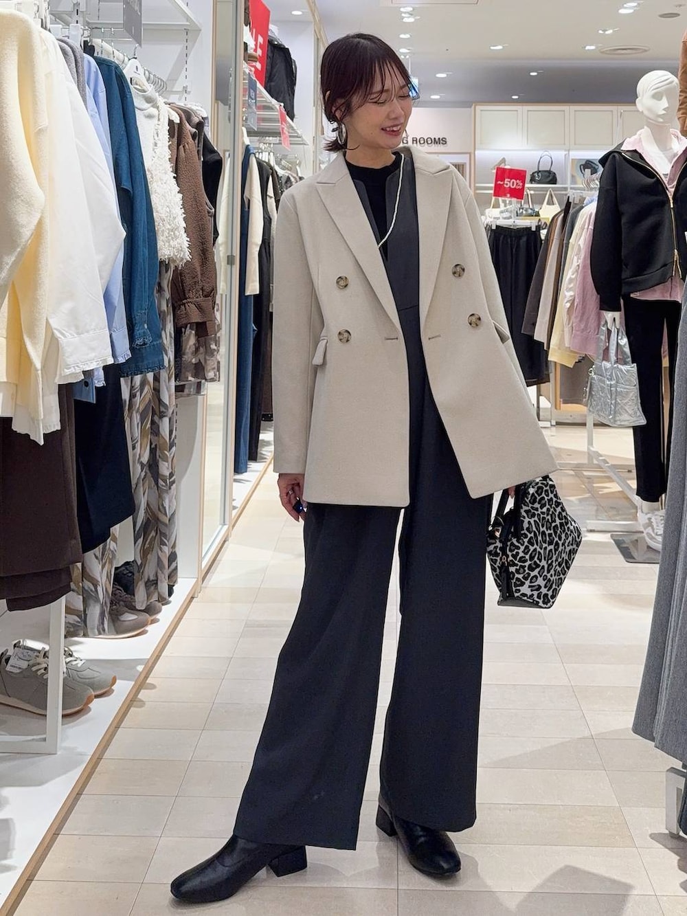 その他のショルダーバッグ、ブラック系のニット/セーター、ブラック系のブーツを着用したレディースの冬コーディネートの2枚目の写真