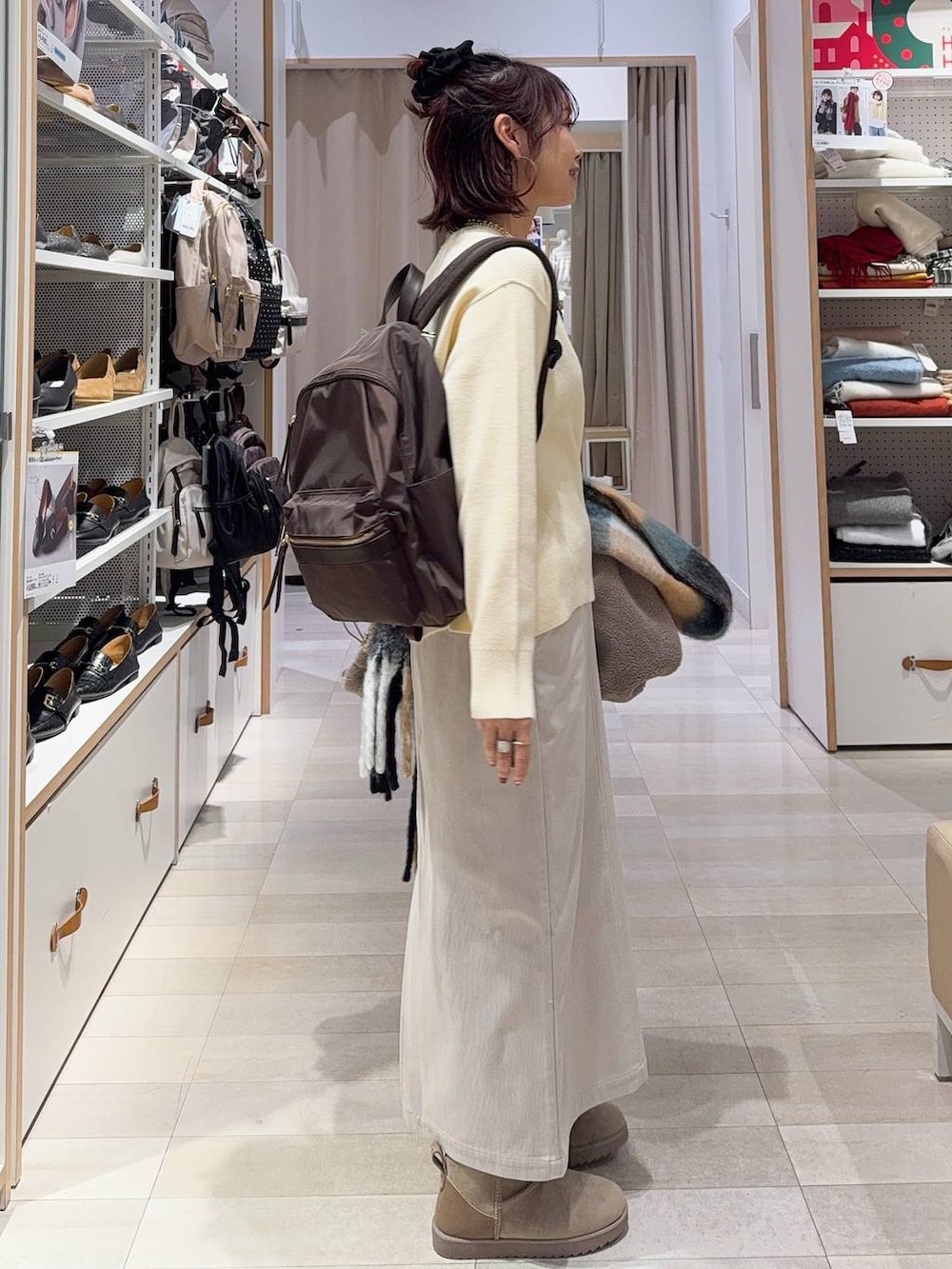 ブラウン系のブルゾン、グレー系のスカート、イエロー系のニット/セーターを着用したレディースの冬コーディネートの7枚目の写真