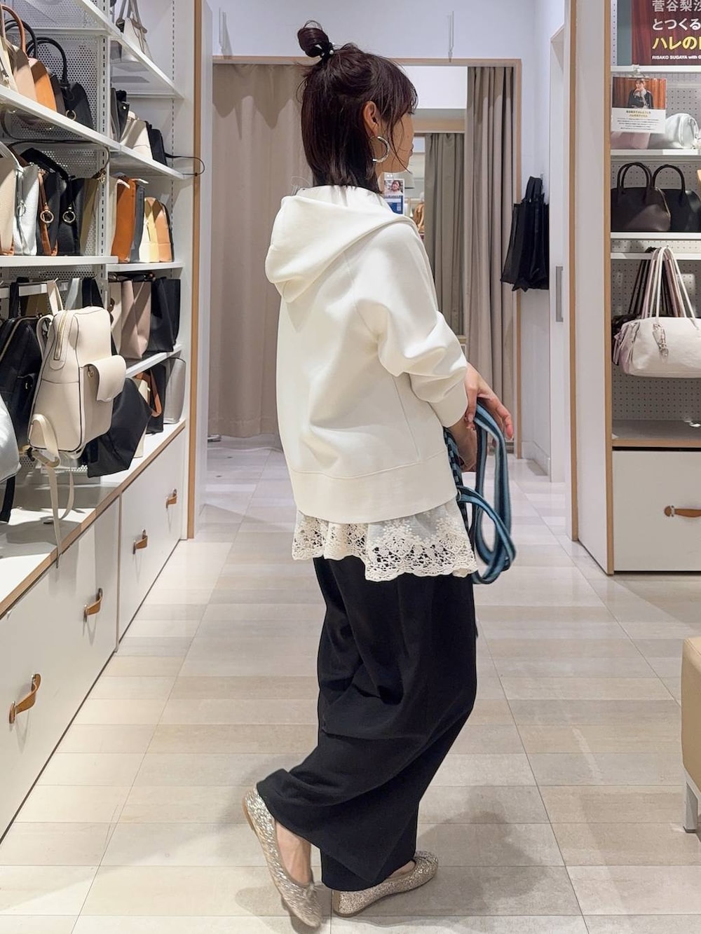 ゴールド系のバレエシューズ、ホワイト系のパーカー、ブルー系のトートバッグを着用したレディースの冬コーディネートの8枚目の写真