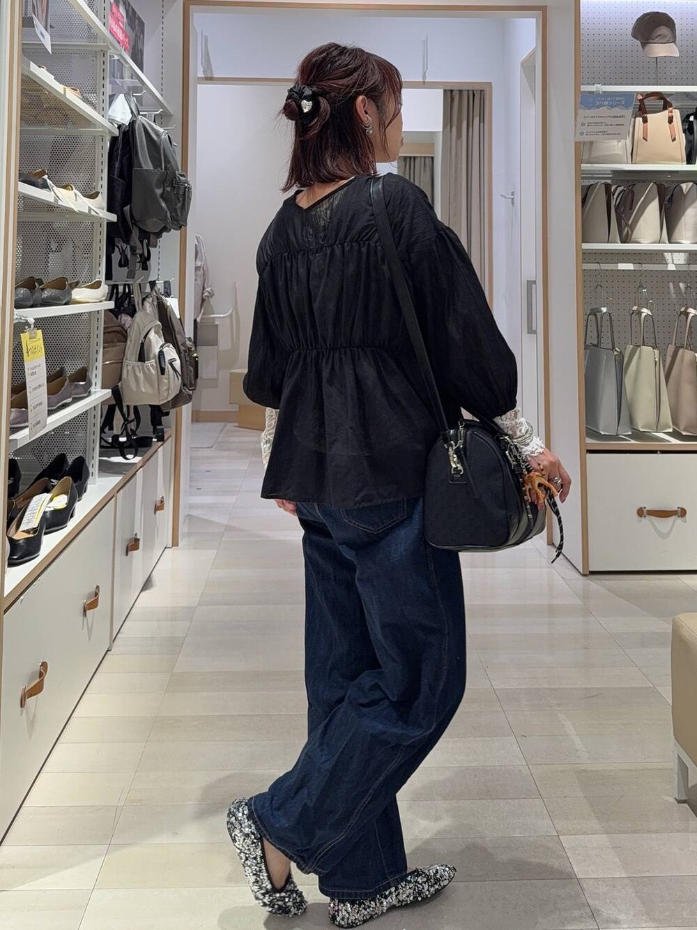 ブルー系のデニムパンツ、ブラック系のボストンバッグ、ブラック系のシャツ/ブラウスを着用したレディースの秋コーディネートの8枚目の写真