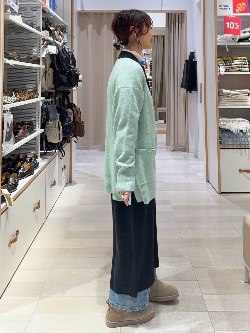 グリーン系のカーディガン/ボレロ、ホワイト系のボストンバッグ、ブラック系のワンピースを着用したレディースの冬コーディネートの4枚目の写真