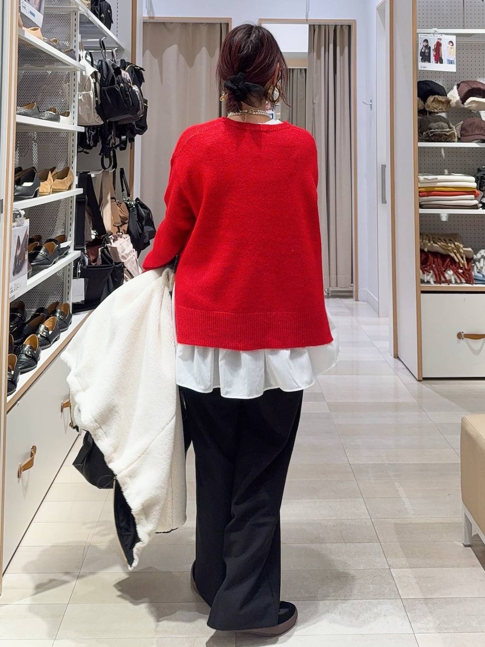 ブラック系のスニーカー、ブラウン系のボストンバッグ、ホワイト系のブルゾンを着用したレディースの冬コーディネートの7枚目の写真