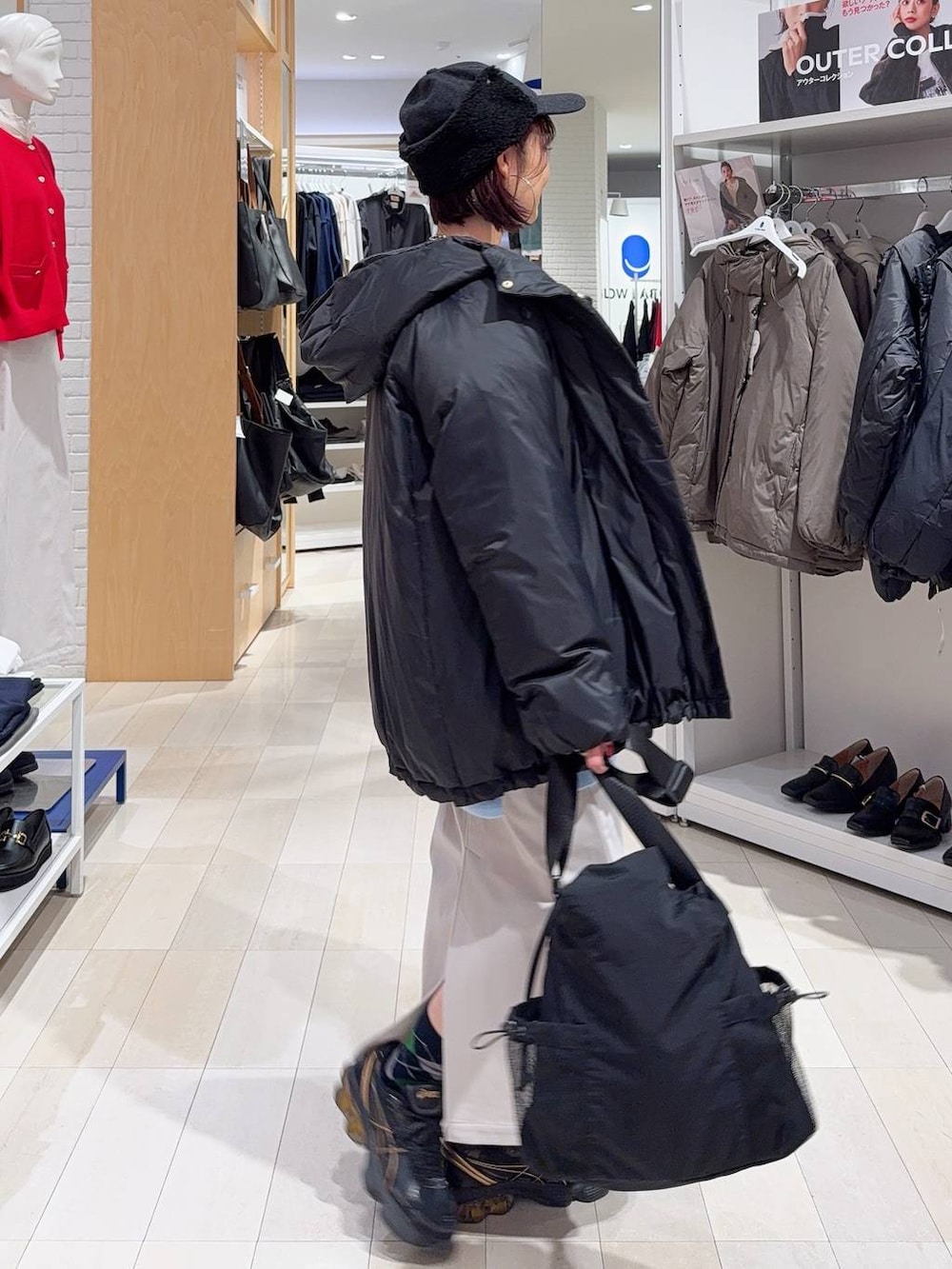 ブラック系のトートバッグ、ブルー系のカーディガン/ボレロ、グレー系のスカートを着用したレディースの秋コーディネートの4枚目の写真