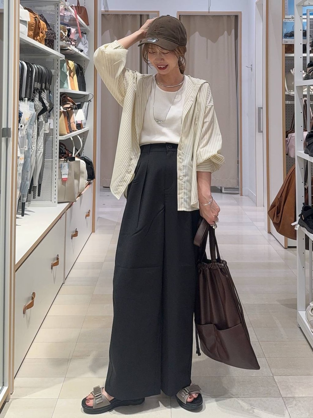ブルー系のデニムパンツ、グレー系のワンピース、ブラウン系のTシャツ/カットソーを着用したレディースの夏コーディネートの3枚目の写真