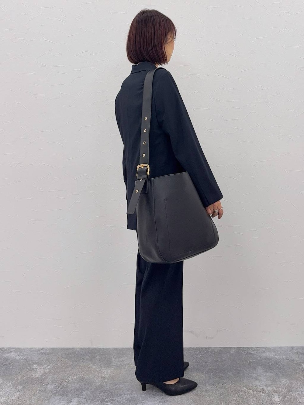 ブラック系のショルダーバッグ、ブルー系のスラックス、ホワイト系のシャツ/ブラウスを着用したレディースの秋コーディネートの3枚目の写真