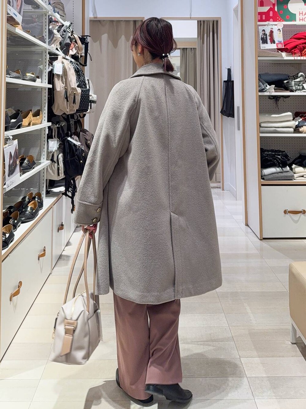 ブラック系のボストンバッグ、ベージュ系のチェスターコート、ピンク系のその他パンツを着用したレディースの冬コーディネートの6枚目の写真