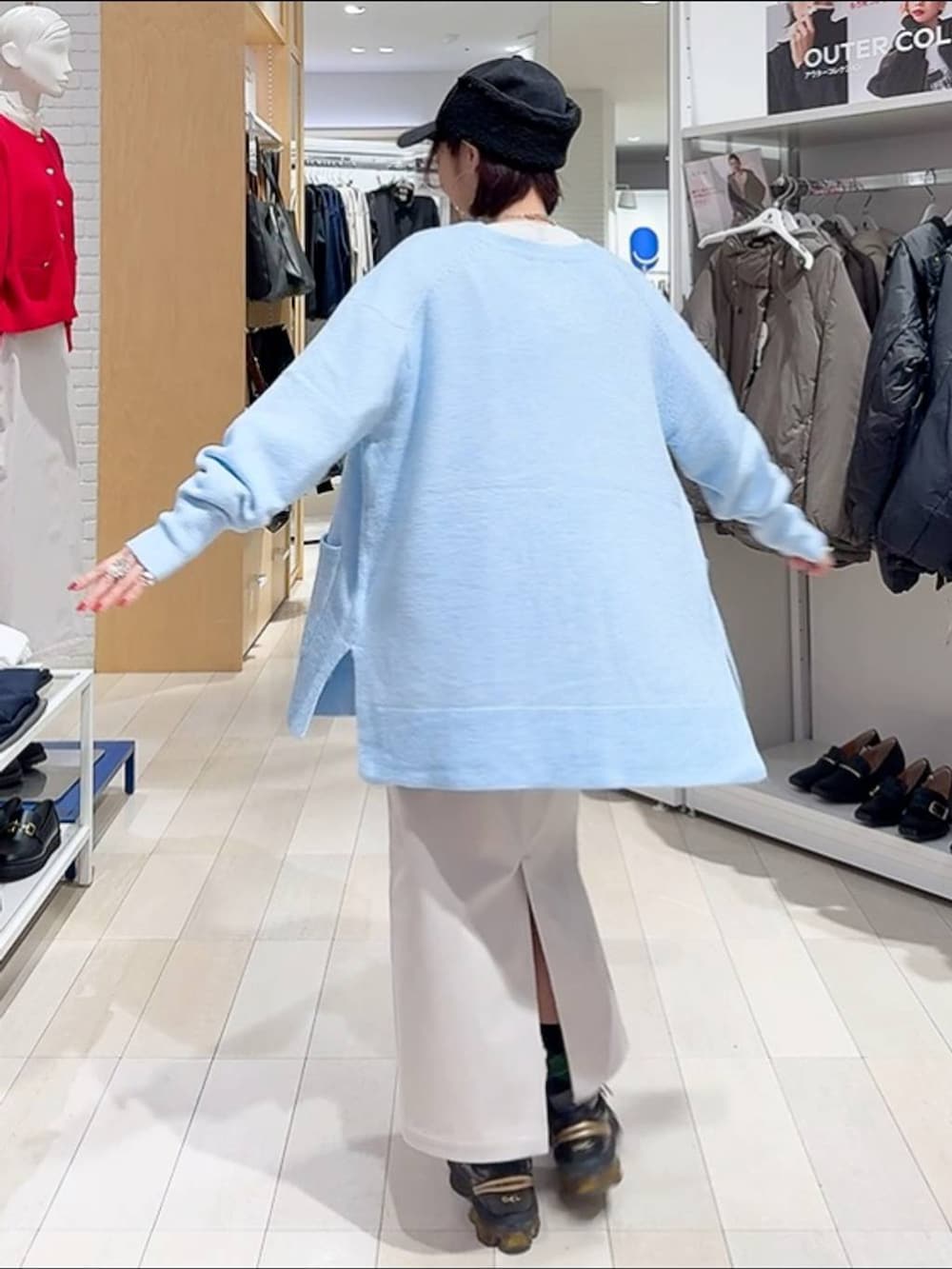 ブラック系のトートバッグ、ブルー系のカーディガン/ボレロ、グレー系のスカートを着用したレディースの秋コーディネートの7枚目の写真