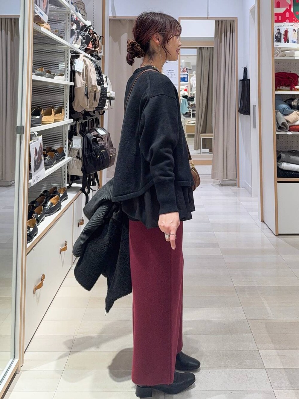 ブラック系のニット/セーター、レッド系のスカート、ブラック系のTシャツ/カットソーを着用したレディースの冬コーディネートの5枚目の写真