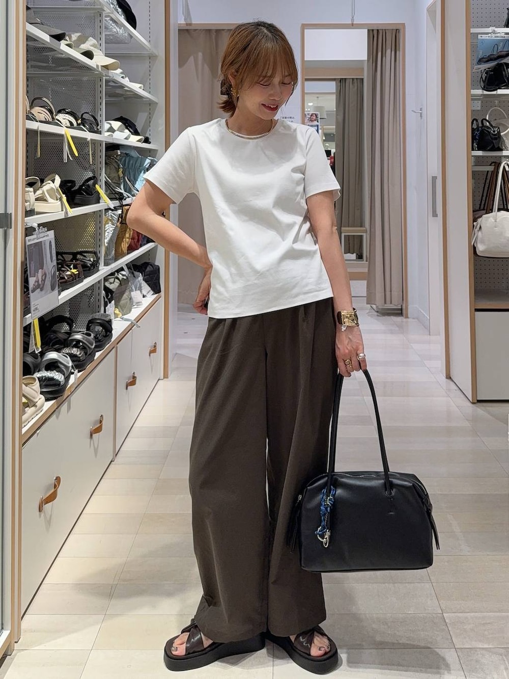 ブラック系のボストンバッグ、ブラウン系のその他パンツ、ホワイト系のTシャツ/カットソーを着用したレディースの夏コーディネートの2枚目の写真