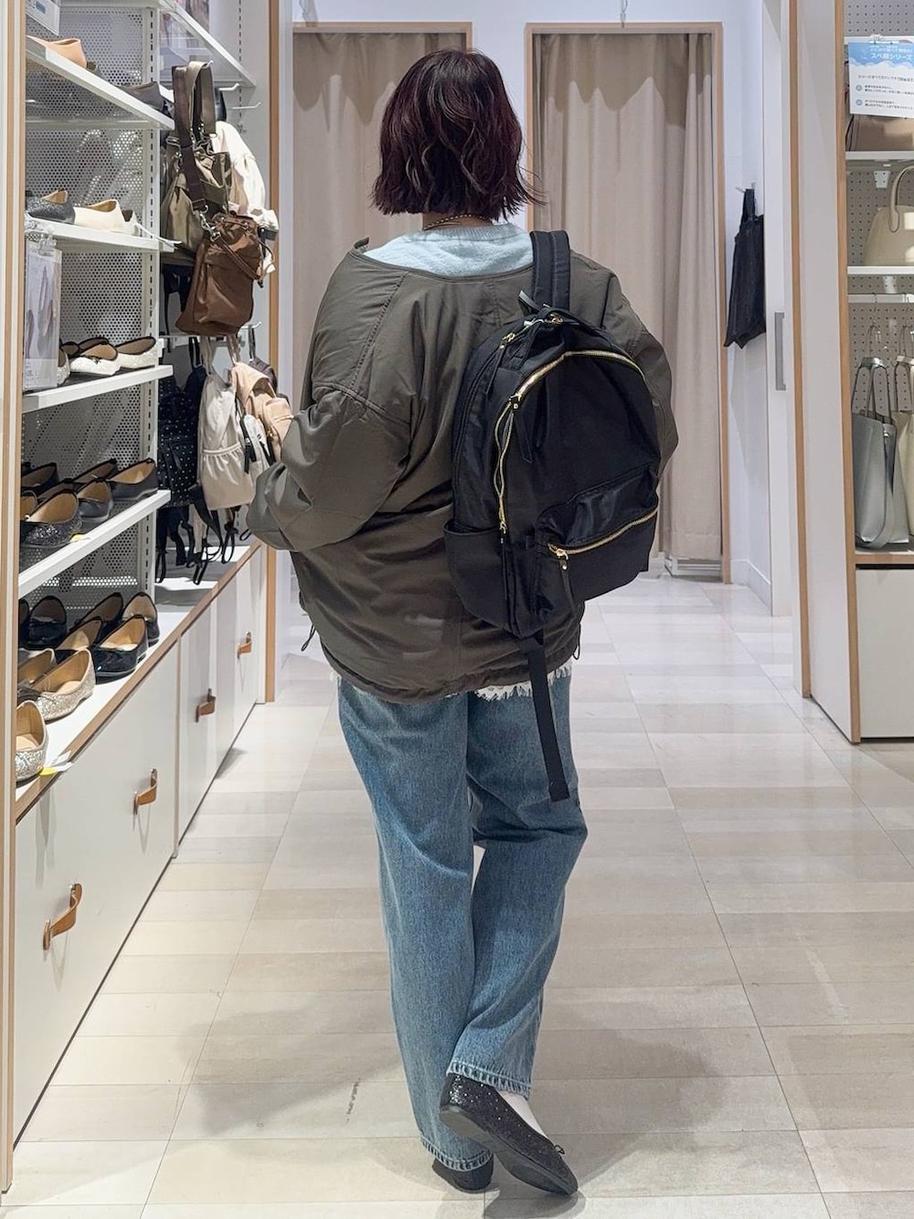 ブラック系のバレエシューズ、グレー系のブルゾン、ブルー系のデニムパンツを着用したレディースの秋コーディネートの7枚目の写真