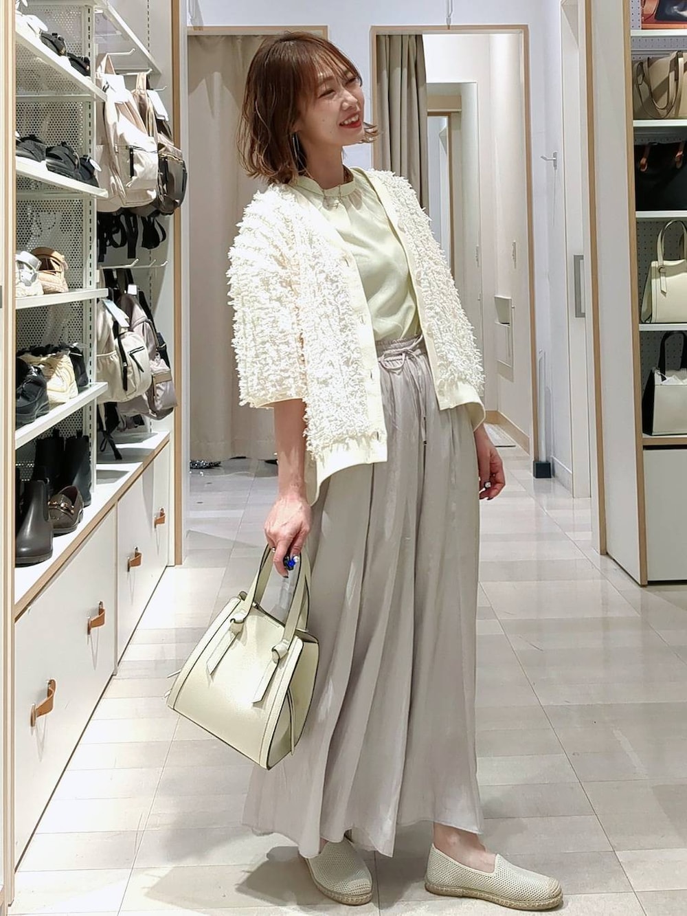 ベージュ系のその他パンツ、ホワイト系のショルダーバッグ、ホワイト系のスリッポンを着用したレディースの春コーディネートの2枚目の写真