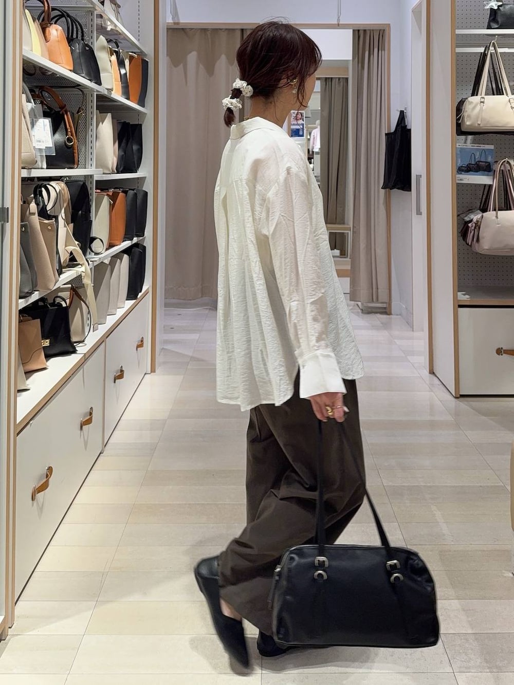 ブラック系のパンプス、ブラウン系のその他パンツ、ホワイト系のタンクトップを着用したレディースの春コーディネートの3枚目の写真