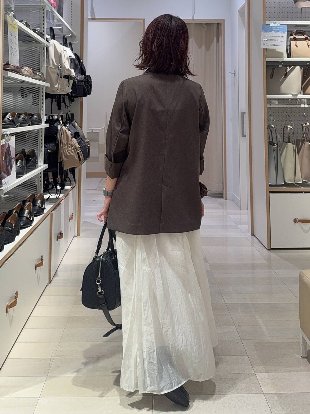 ブラック系のローファー、ホワイト系のキャミソール、ブラウン系のテーラードジャケットを着用したレディースの秋コーディネートの9枚目の写真