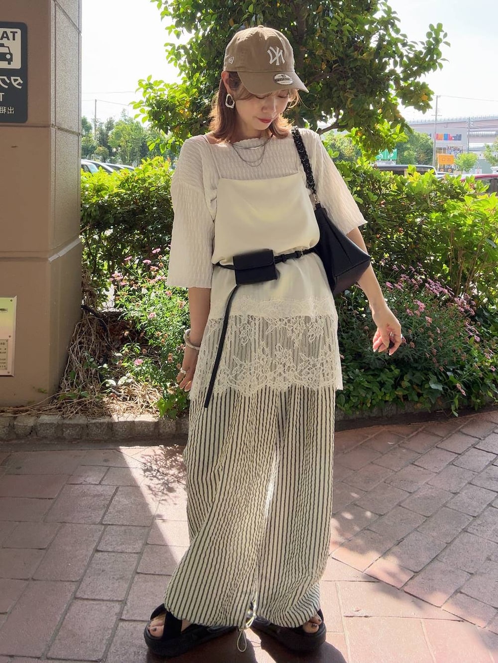 グレー系のTシャツ/カットソー、ブラウン系のサンダル、ホワイト系のその他パンツを着用したレディースの夏コーディネートの7枚目の写真